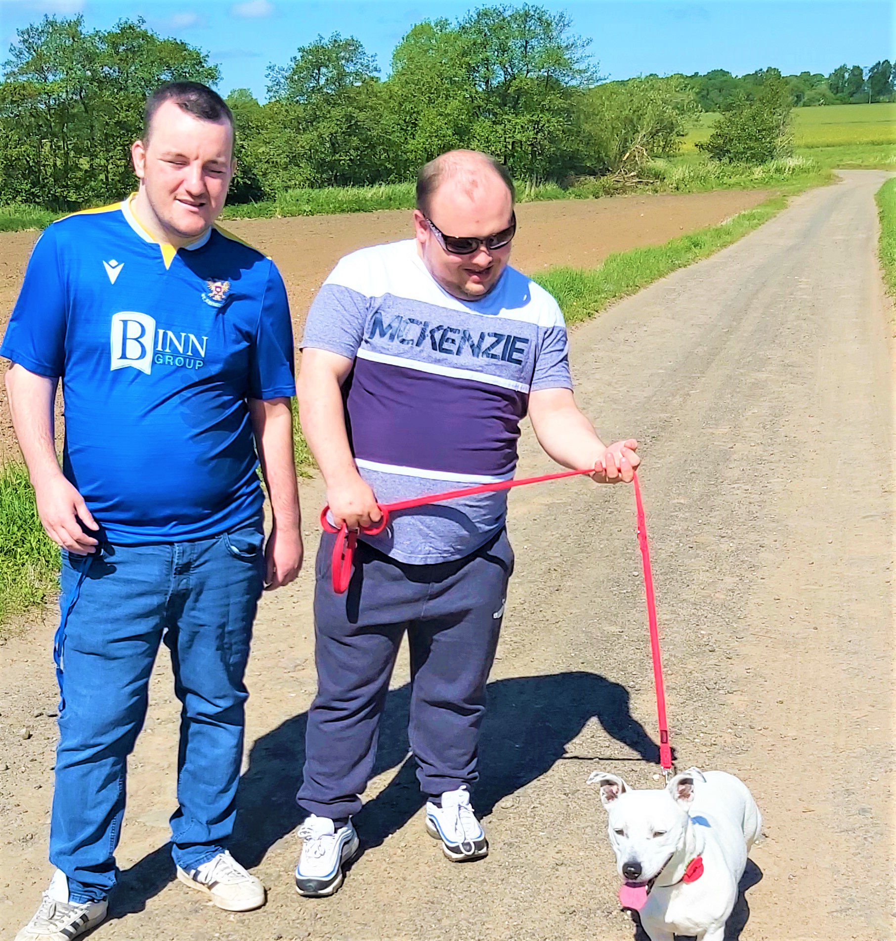 service users walking dog on farm track