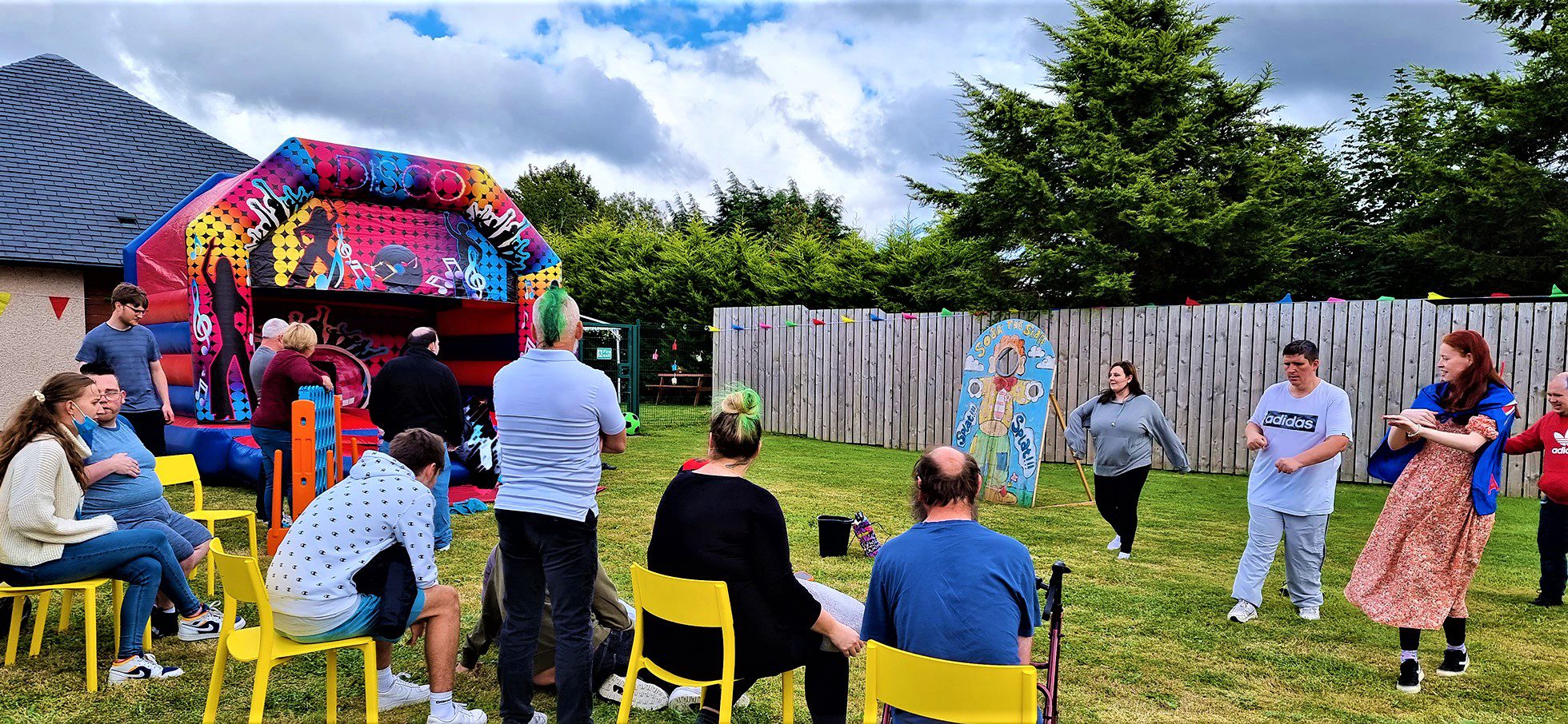 service users outdoor party with bouncy castle